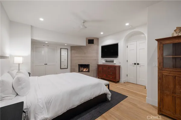 a spacious bedroom with a bed and a flat screen tv