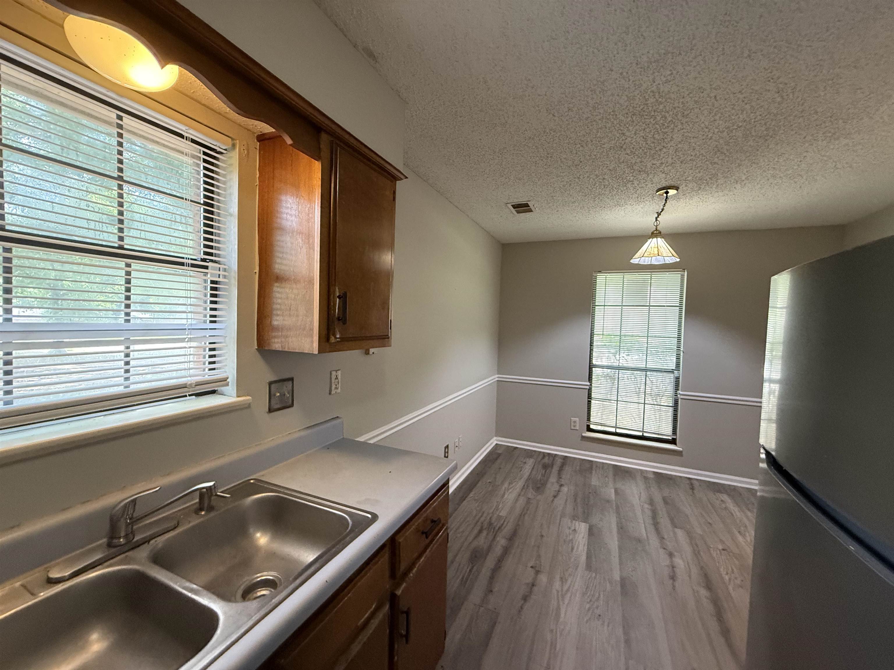 6420 Saginaw Road Memphis, TN 38134 - Photo 12 of 38 Kitchen area featuring double basin stainless steel sink, wood cabinetry, and a window with blinds