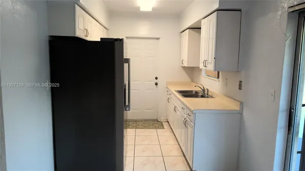 a kitchen with a refrigerator and a stove top oven
