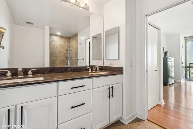 a bathroom with double sink and a mirror