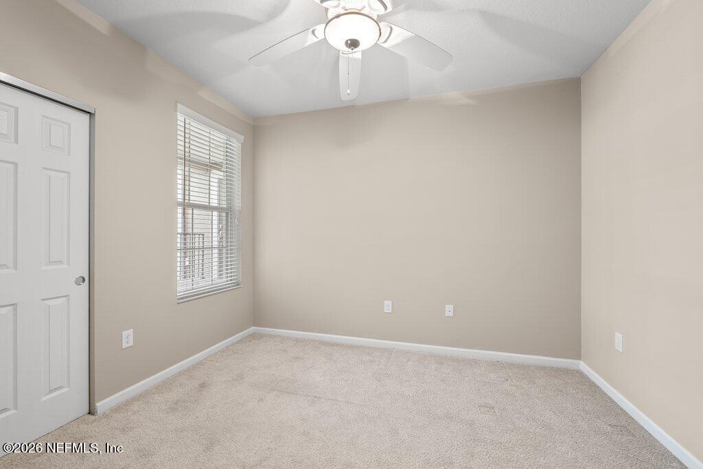 8757 Little Swift Circle, Unit 22F Jacksonville, FL 32256 - Photo 14 of 46 an empty room with windows and chandelier fan