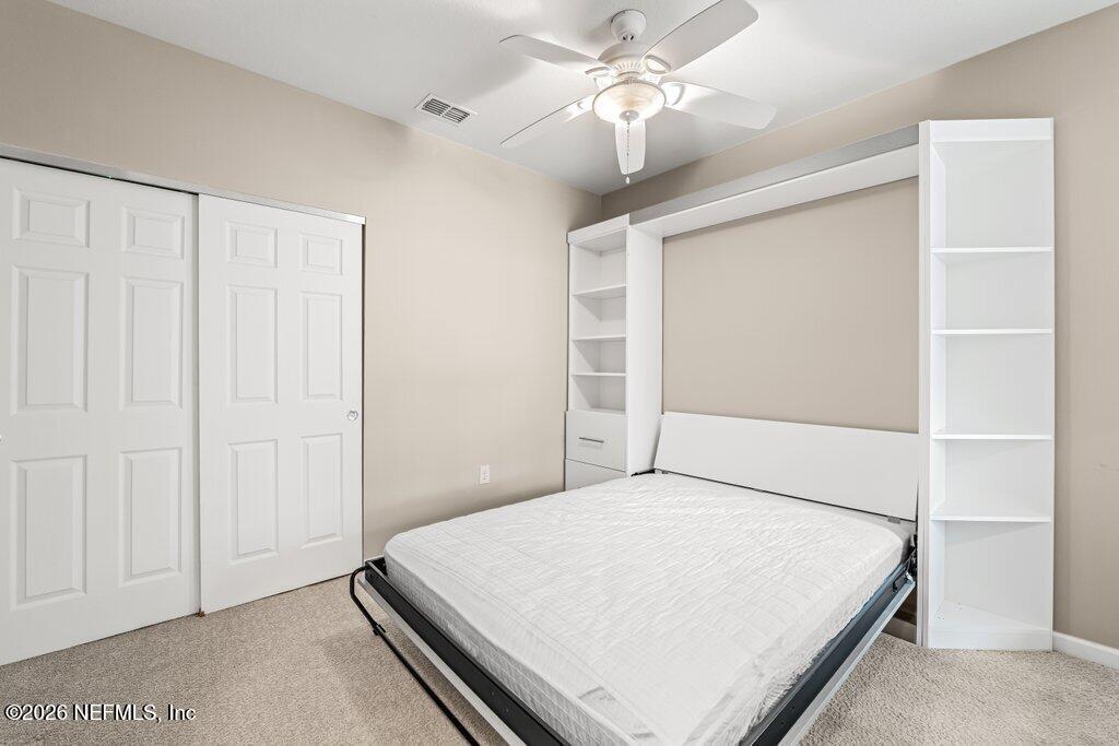 8757 Little Swift Circle, Unit 22F Jacksonville, FL 32256 - Photo 9 of 46 a bedroom with a bed and a chandelier