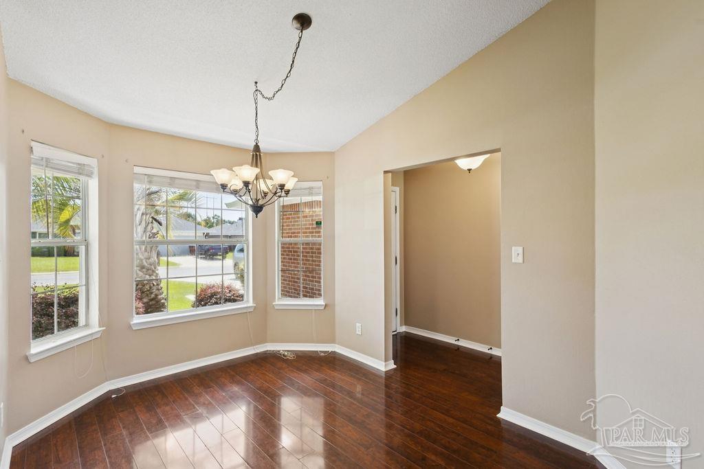 5661 Berrybrook Circle Pace, FL 32571 - Photo 7 of 21 a view of an empty room with window and wooden floor