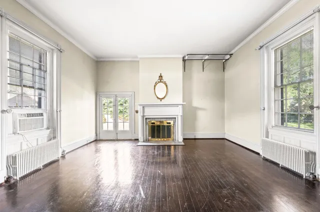 an empty room with window and wooden floor
