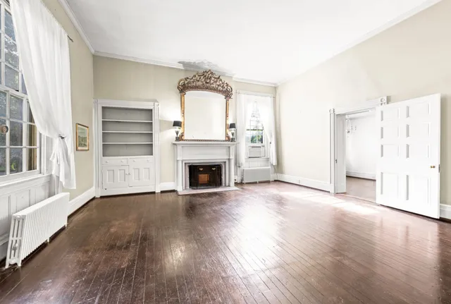 a view of a livingroom with wooden floor and a fireplace