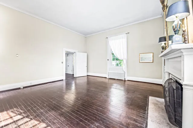 a kitchen with a refrigerator a stove a sink and white cabinets with wooden floor