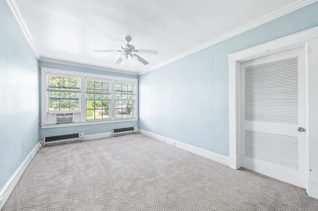 a view of a livingroom with wooden floor a fireplace and windows