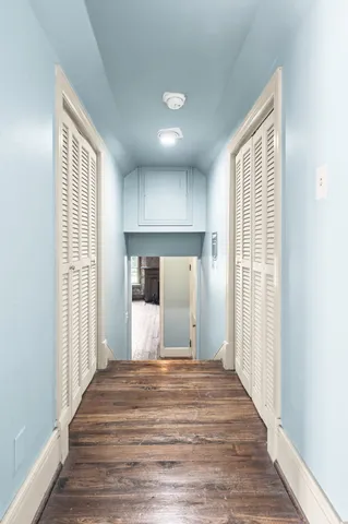a front view of a house with garden and trees