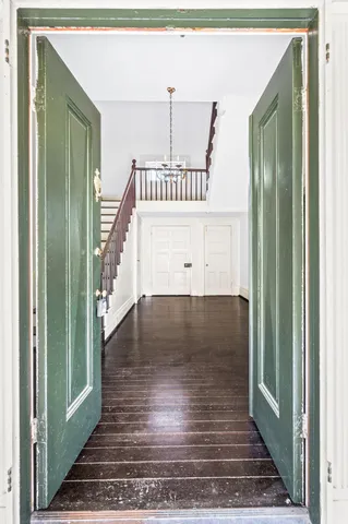a view of a hallway with wooden floor and staircase
