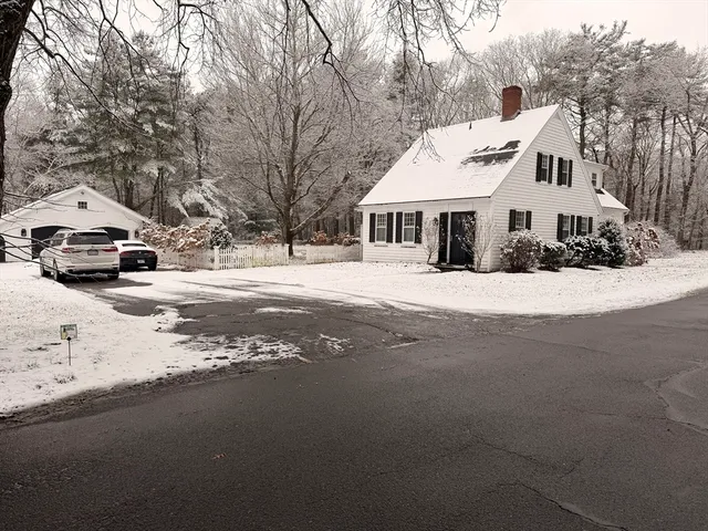 a front view of a house with a yard covered with snow in front of house