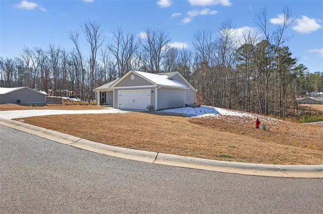a white house with a snow on the side of the road
