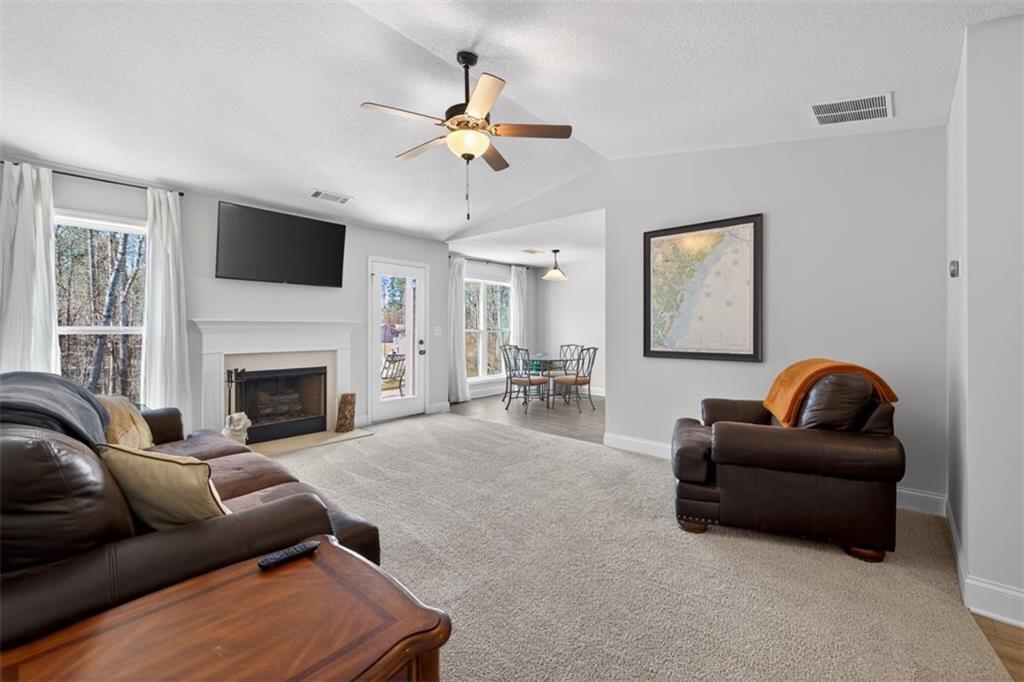 142 Rolling Wds Lane Colbert, GA 30628 - Photo 16 of 34 a living room with furniture a flat screen tv and a fireplace