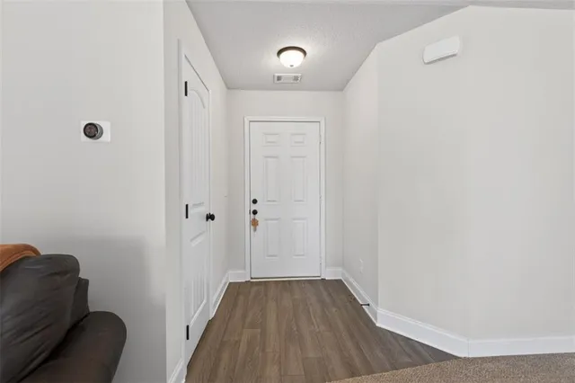 a view of a hallway with wooden floor and closet