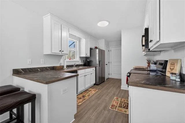 a kitchen with granite countertop a sink stove and refrigerator