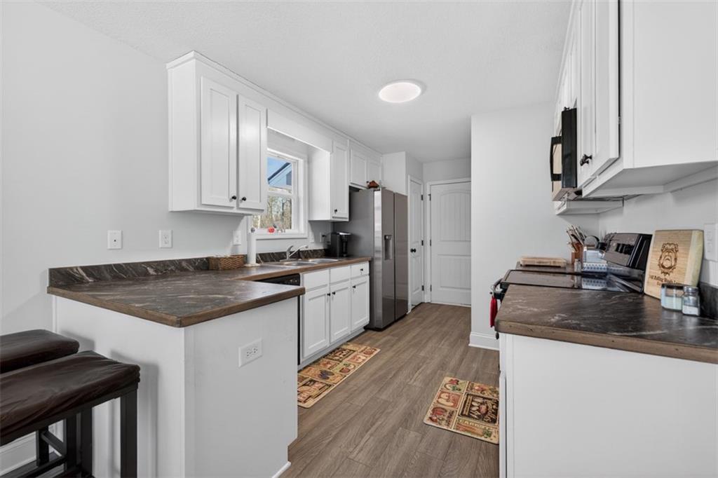 142 Rolling Wds Lane Colbert, GA 30628 - Photo 20 of 34 a kitchen with granite countertop a sink stove and refrigerator