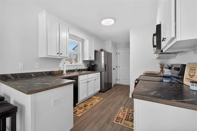 a kitchen with granite countertop a sink stove and refrigerator