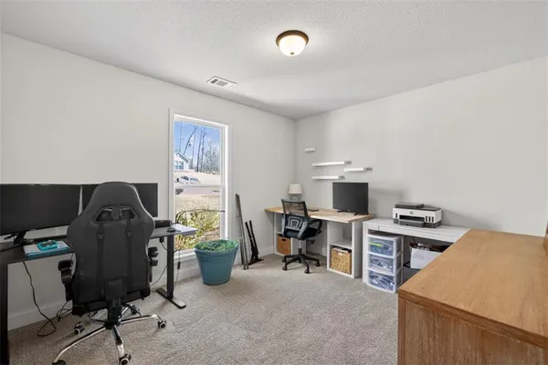 a view of a workspace with furniture and a window