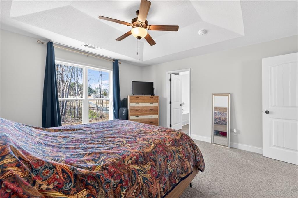 142 Rolling Wds Lane Colbert, GA 30628 - Photo 28 of 34 a bedroom with a bed and a chandelier