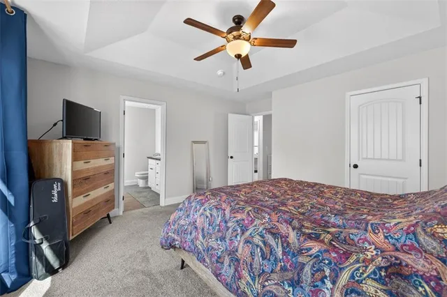 a bedroom with a bed and a flat tv screen on dresser
