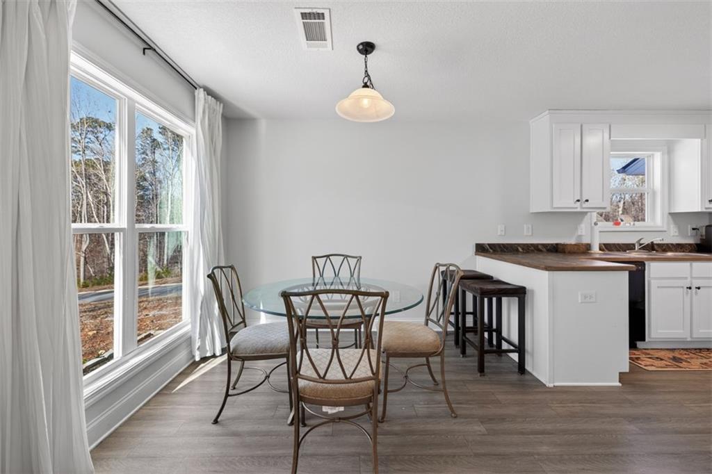 142 Rolling Wds Lane Colbert, GA 30628 - Photo 3 of 34 a view of a dining room with furniture and wooden floor