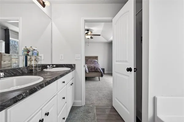a en suite bathroom with a granite countertop sink and a mirror