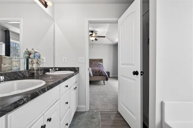 a en suite bathroom with a granite countertop sink and a mirror