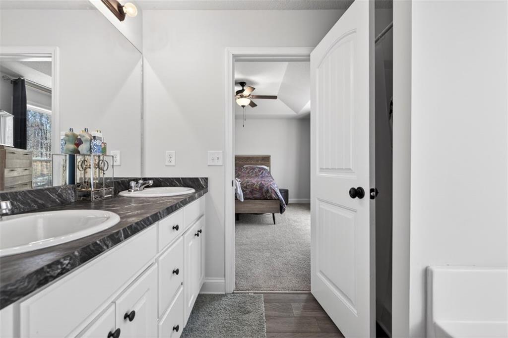 142 Rolling Wds Lane Colbert, GA 30628 - Photo 32 of 34 a en suite bathroom with a granite countertop sink and a mirror