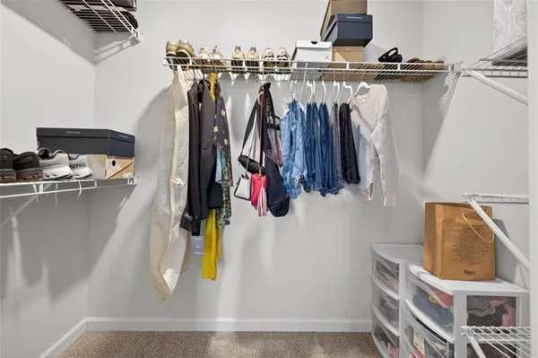 a view of walk in closet with clothes and shoes