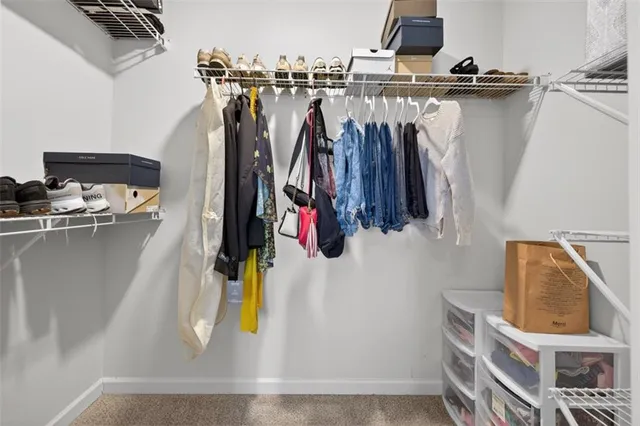 a view of walk in closet with clothes and shoes