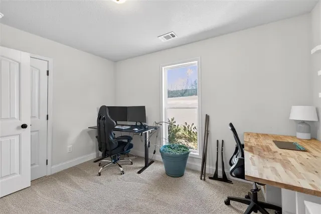 a view of a workspace with furniture and a window