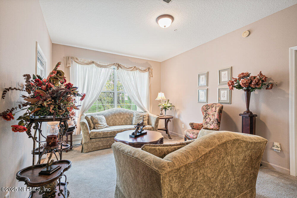 7801 Point Meadows Drive, Unit 3209 Jacksonville, FL 32256 - Photo 14 of 34 a living room with furniture and a large window