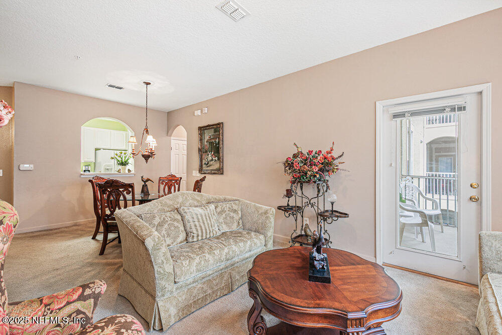 7801 Point Meadows Drive, Unit 3209 Jacksonville, FL 32256 - Photo 15 of 34 a living room with furniture and a chandelier