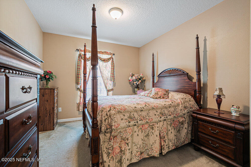 7801 Point Meadows Drive, Unit 3209 Jacksonville, FL 32256 - Photo 17 of 34 a bedroom with a bed dresser and a window