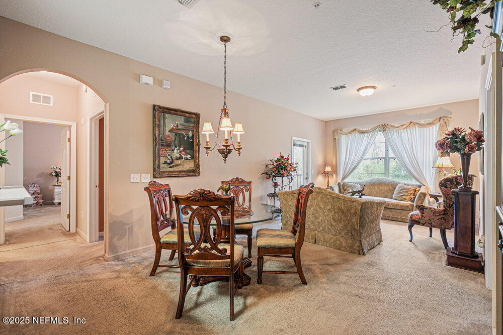 7801 Point Meadows Drive, Unit 3209 Jacksonville, FL 32256 - Photo 2 of 34 a dining room with furniture a chandelier and window