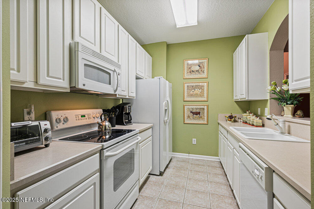 7801 Point Meadows Drive, Unit 3209 Jacksonville, FL 32256 - Photo 3 of 34 a kitchen with stainless steel appliances granite countertop a sink stove and refrigerator