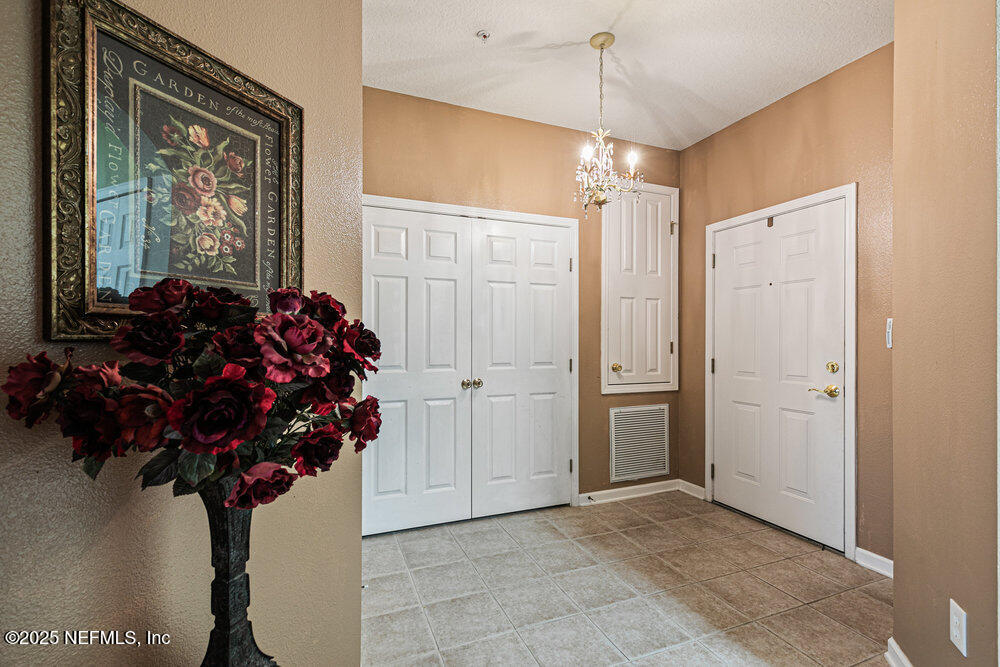 7801 Point Meadows Drive, Unit 3209 Jacksonville, FL 32256 - Photo 9 of 34 a vase of flowers sitting on a floor in front of a house