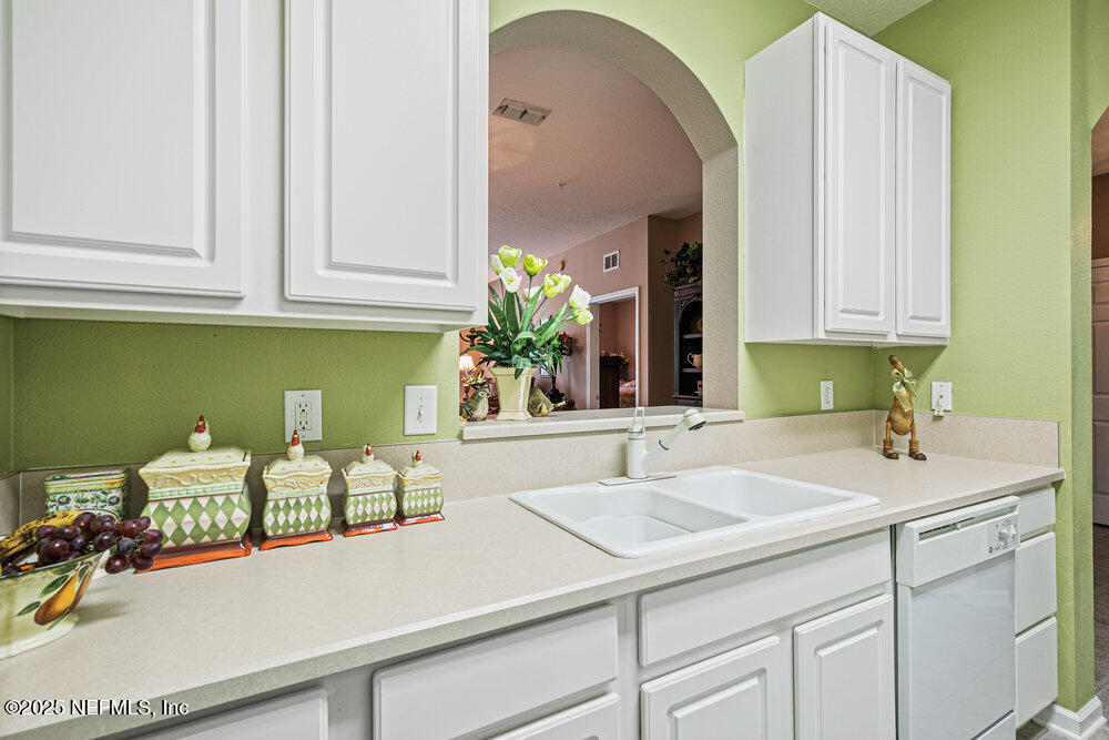7801 Point Meadows Drive, Unit 3209 Jacksonville, FL 32256 - Photo 10 of 34 a kitchen with white cabinets and sink
