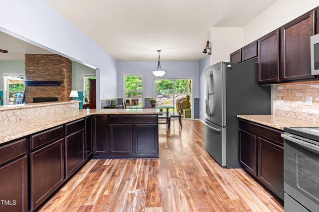 a large kitchen with stainless steel appliances granite countertop a refrigerator a stove and a sink