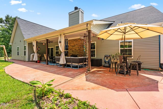 a view of a patio with table and chairs potted plants with wooden floor and fence