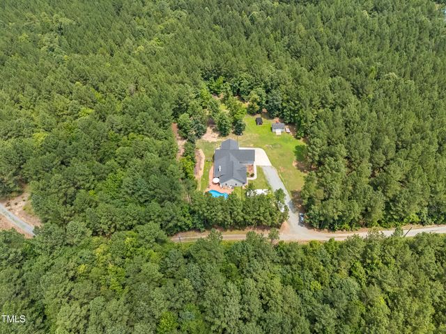 a house view with swimming pool and garden space