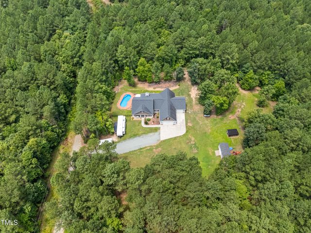 an aerial view of residential house with outdoor space and trees all around