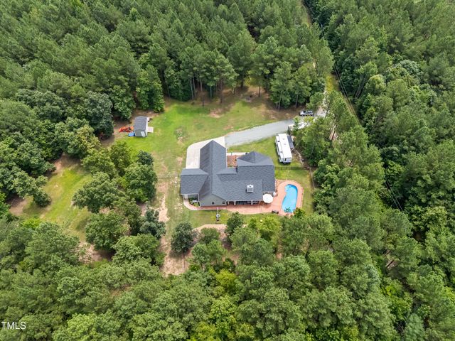 an aerial view of a house with a yard basket ball court and outdoor seating