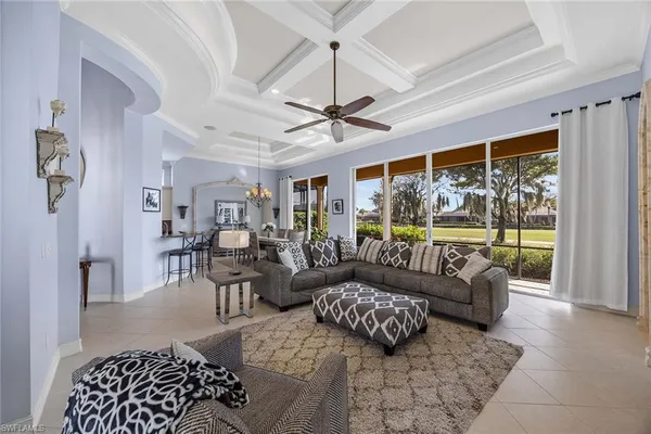 a living room with furniture ceiling fan and a large window