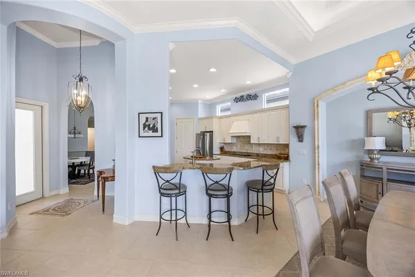 a kitchen with stainless steel appliances granite countertop a stove top oven a refrigerator a sink and white cabinets