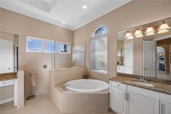 a bathroom with a granite countertop sink a toilet a mirror and bathtub