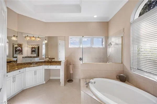 a en suite bathroom with a granite countertop sink and mirror