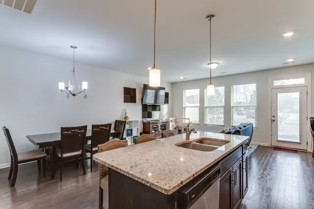 a view of a dining room and livingroom with furniture wooden floor a chandelier