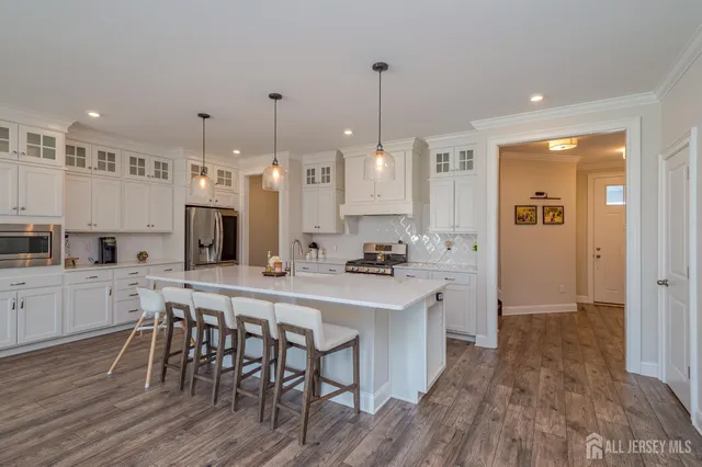 a kitchen with stainless steel appliances a dining table chairs stove sink and cabinets