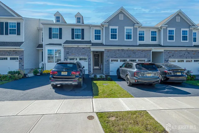 a view of a car parked in front of a brick house with a small yard