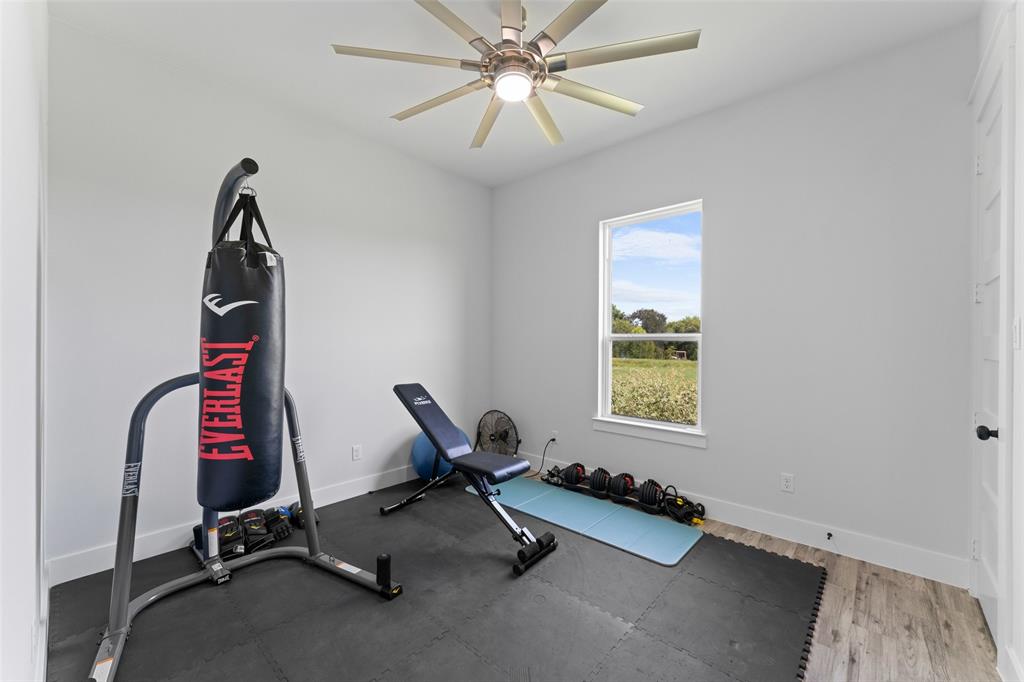 4411 Fm 751 Wills Point Wills Point, TX 75169 - Photo 33 of 40 Versatile room featuring light grey walls, wood-finish flooring, and a ceiling fan with integrated lighting